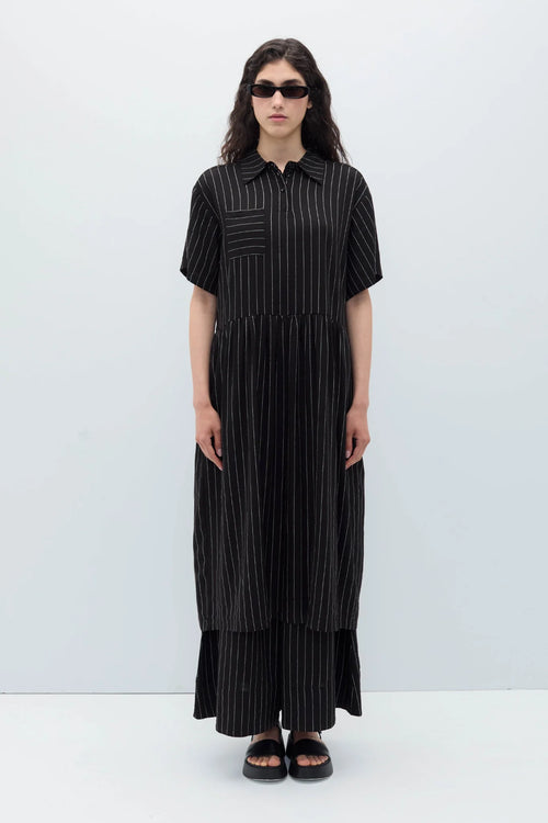 Woman wearing a black espelma pinstripe dress by Rita Row against a white background