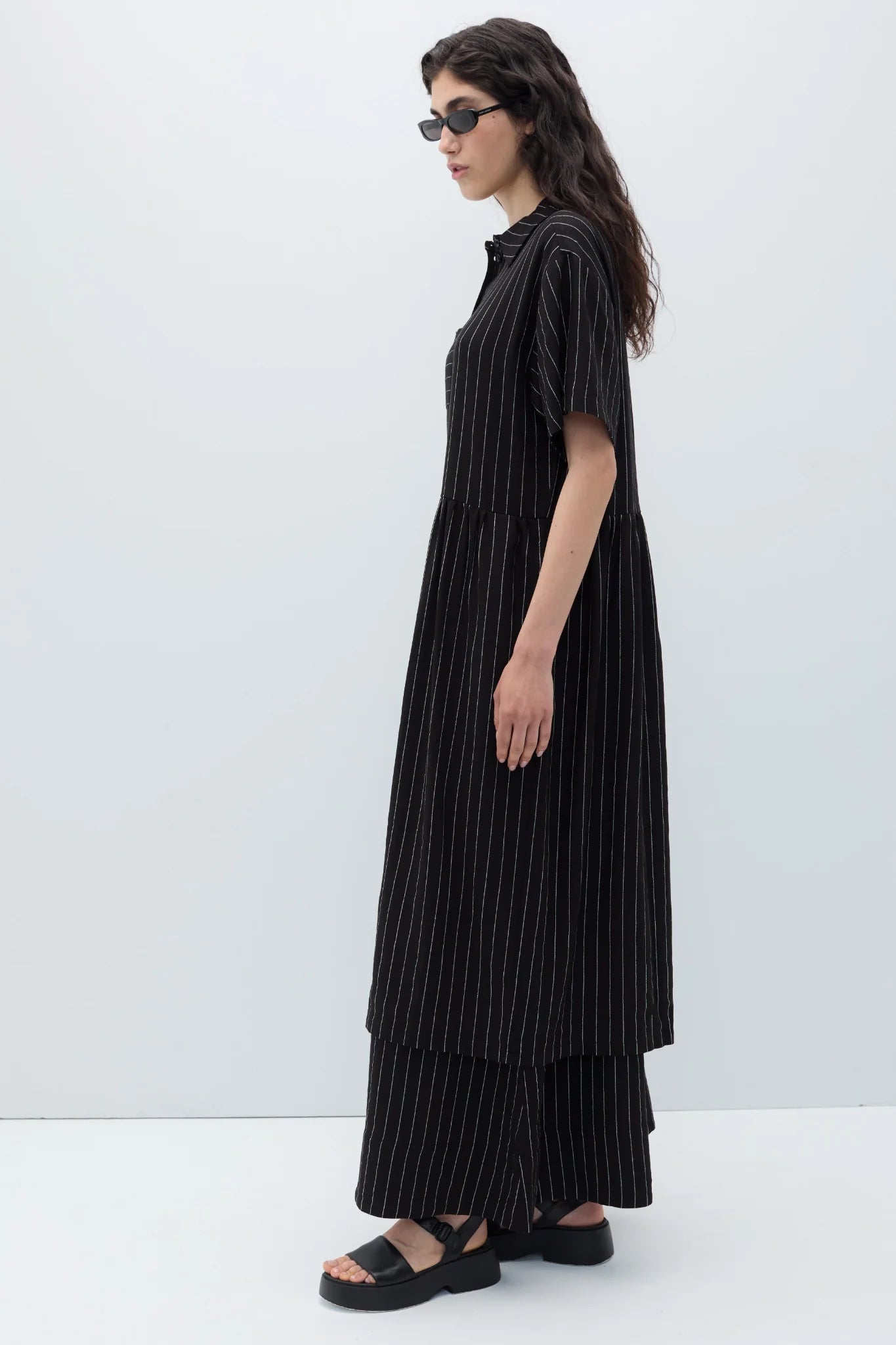Woman wearing a black espelma pinstripe dress by Rita Row against a white background