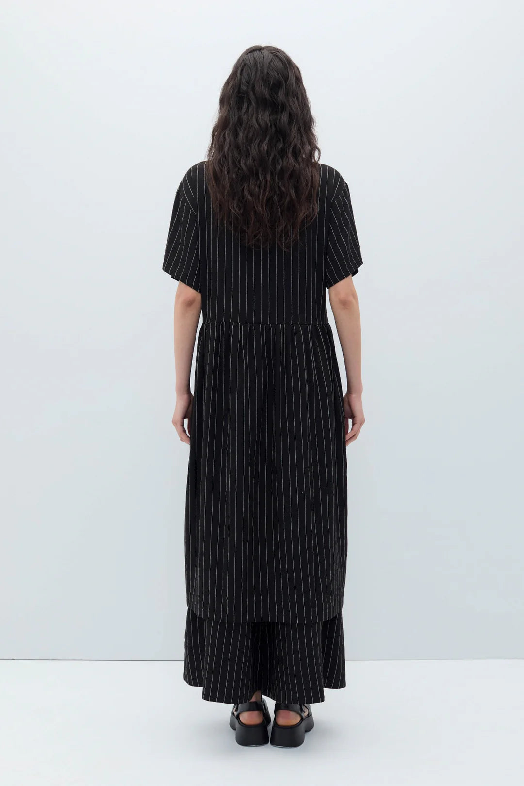 Woman wearing a black espelma pinstripe dress by Rita Row against a white background