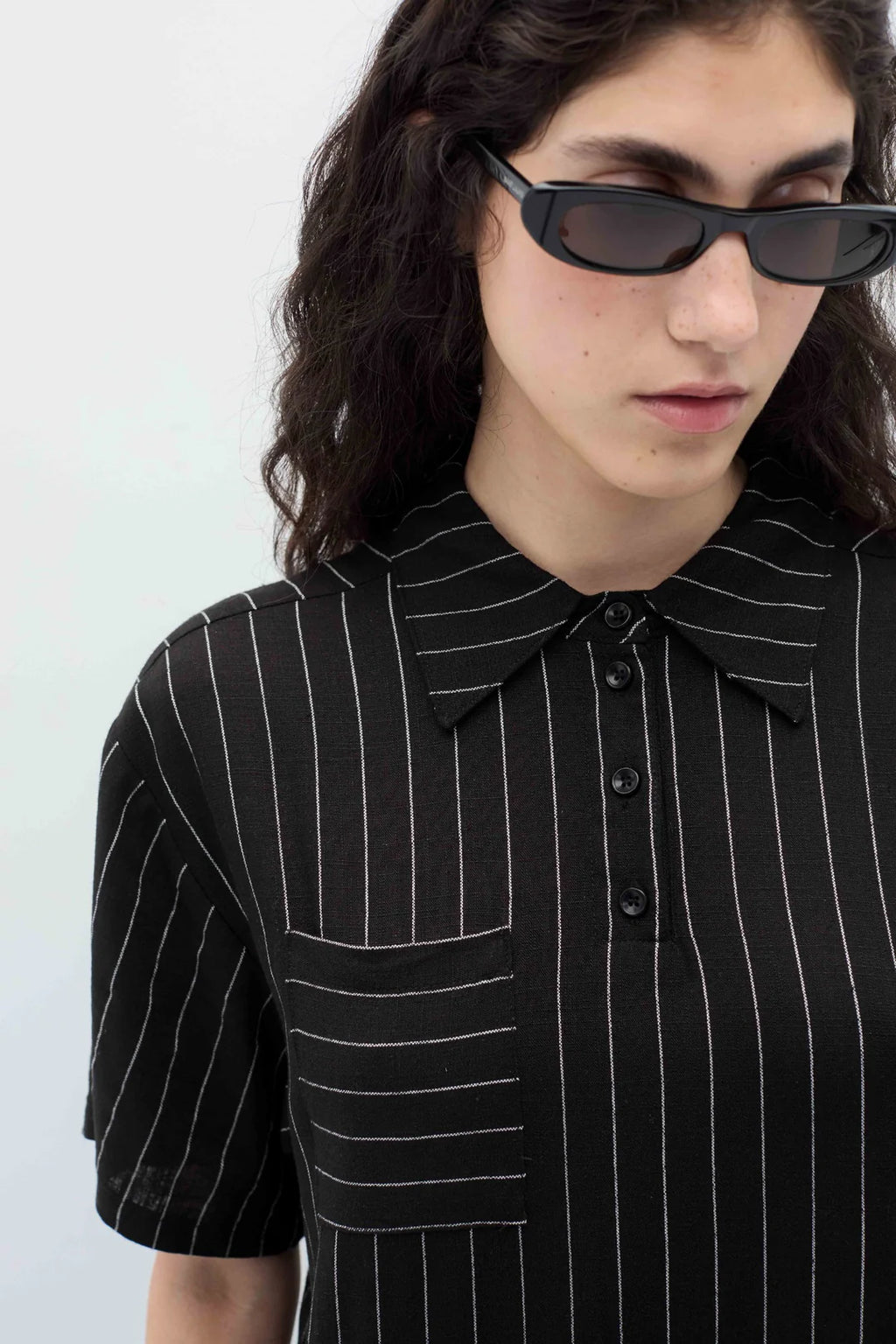 Woman wearing a black espelma pinstripe dress by Rita Row against a white background