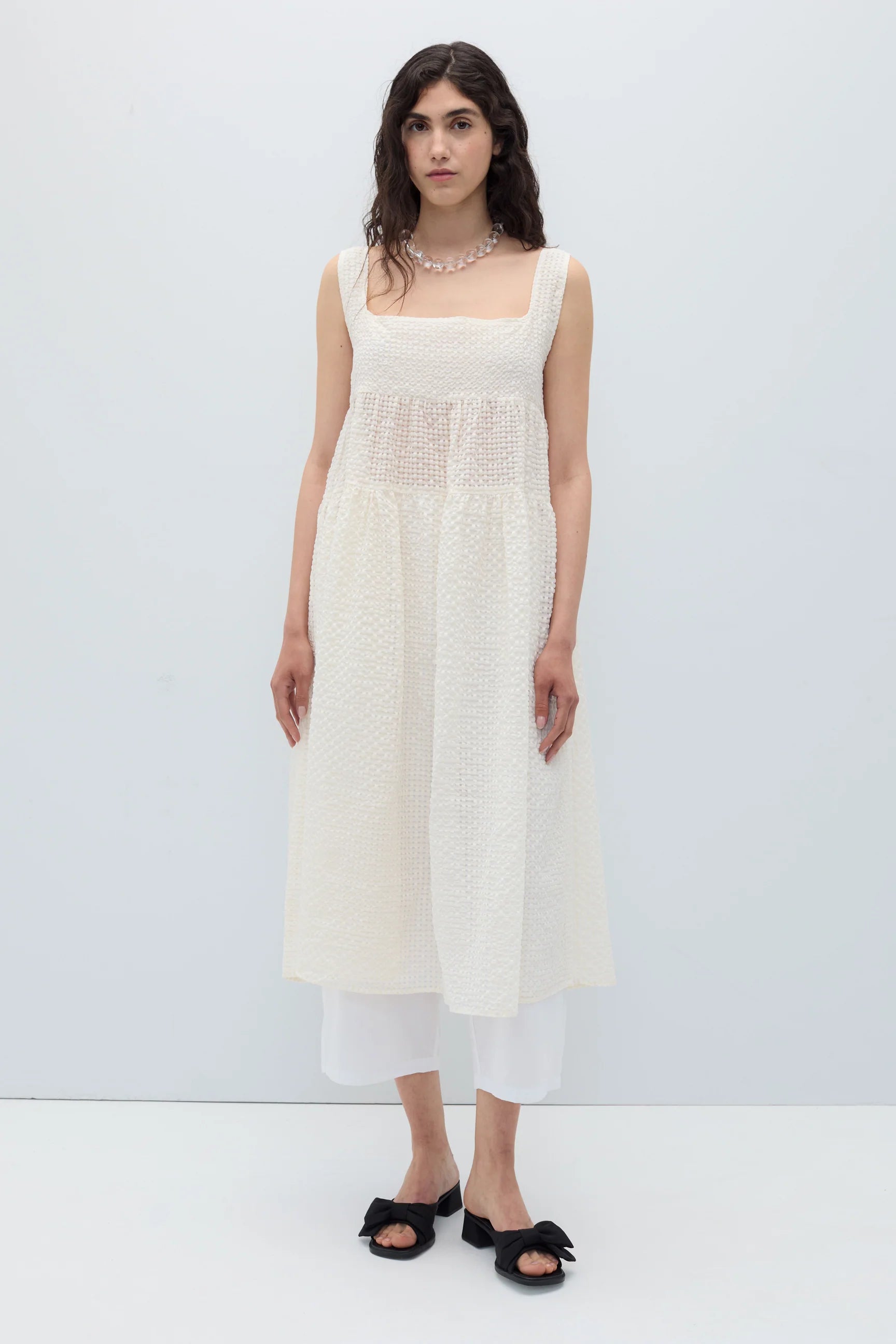 Woman wearing a white sleeveless Saint dress by Rita Row on a plain background