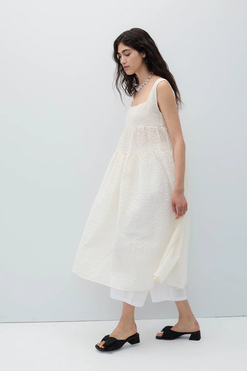 Woman wearing a white sleeveless Saint dress by Rita Row on a plain background