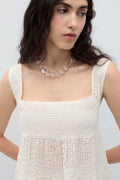 Woman wearing a white sleeveless Saint dress by Rita Row on a plain background