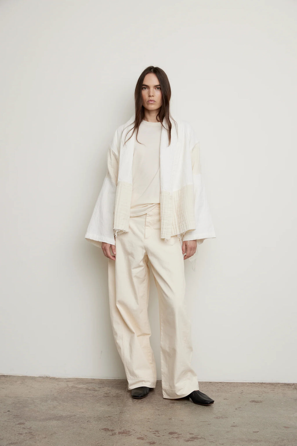 Woman wearing a White/Cream Kimono y Atelier Delphine with a cream outfit in front of a white background.