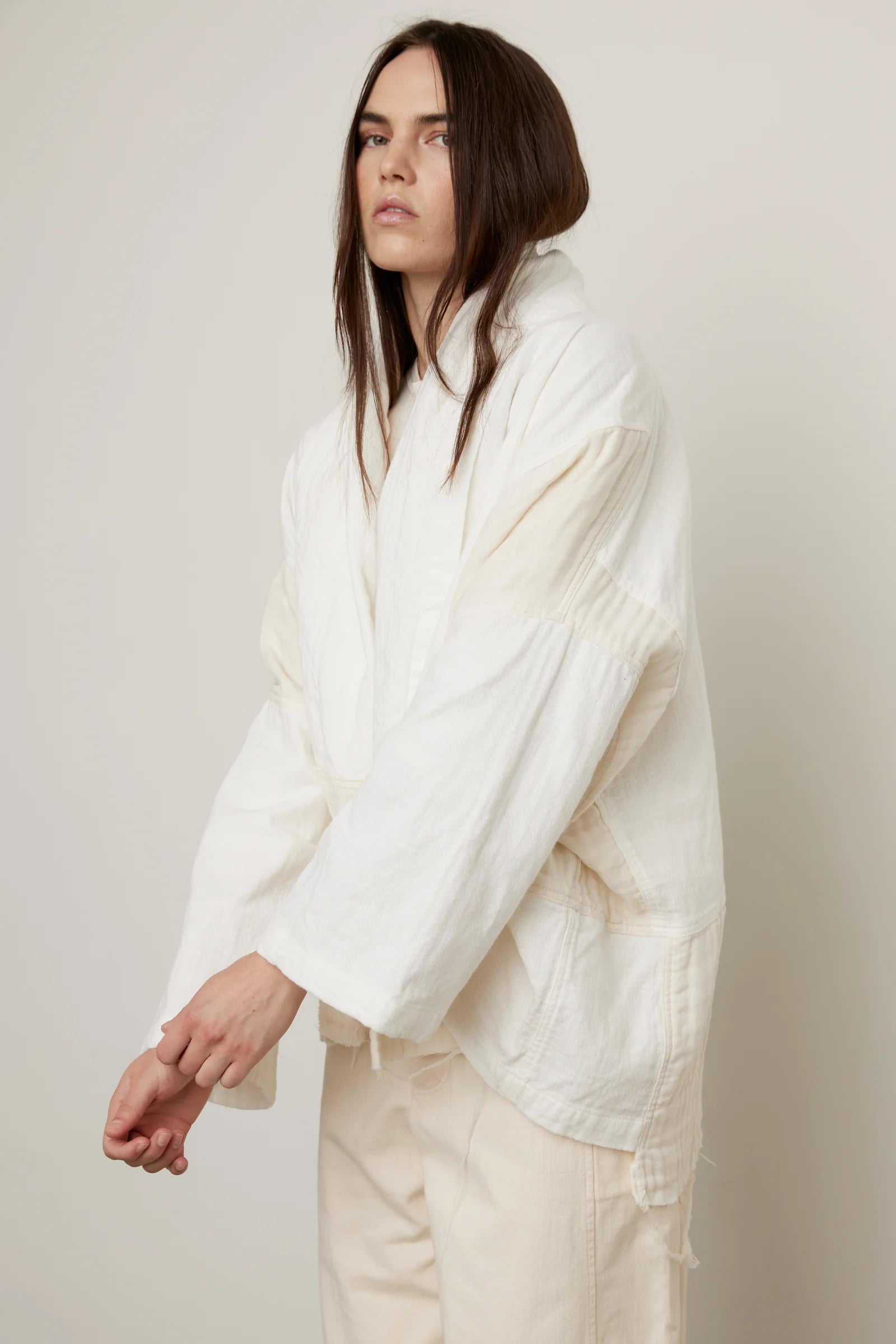 Woman wearing a White/Cream Kimono y Atelier Delphine with a cream outfit in front of a white background.