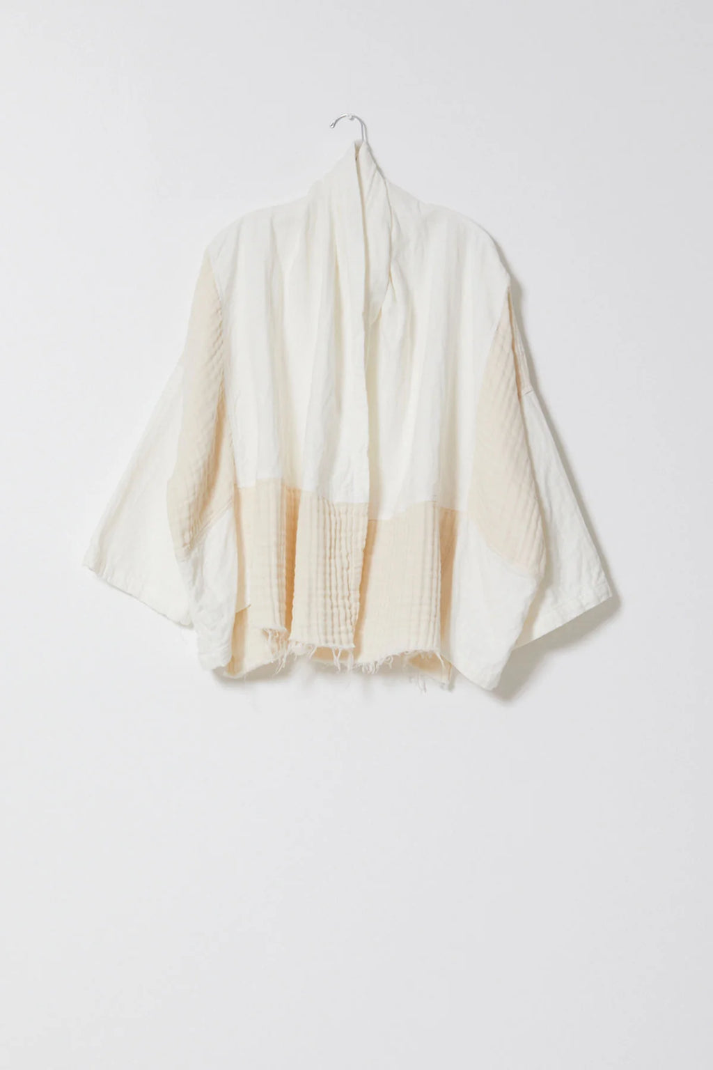 Woman wearing a White/Cream Kimono y Atelier Delphine with a cream outfit in front of a white background.