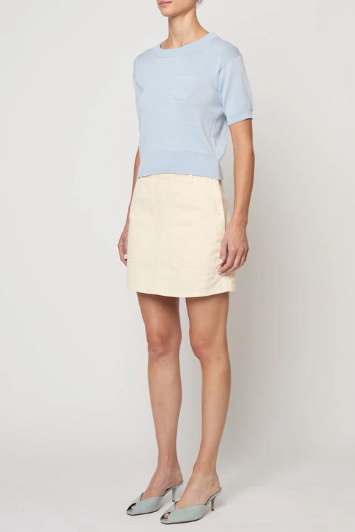 Woman wearing Pastel Blue Mari Top by Atelier Delphine and a cream skirt on a white background