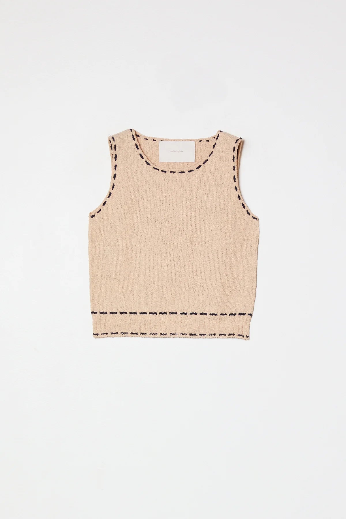 A beige sleeveless top with navy stitching by Atelier Delphine 