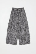 Black and white gingham pants by Atelier Delphine on a light gray background 