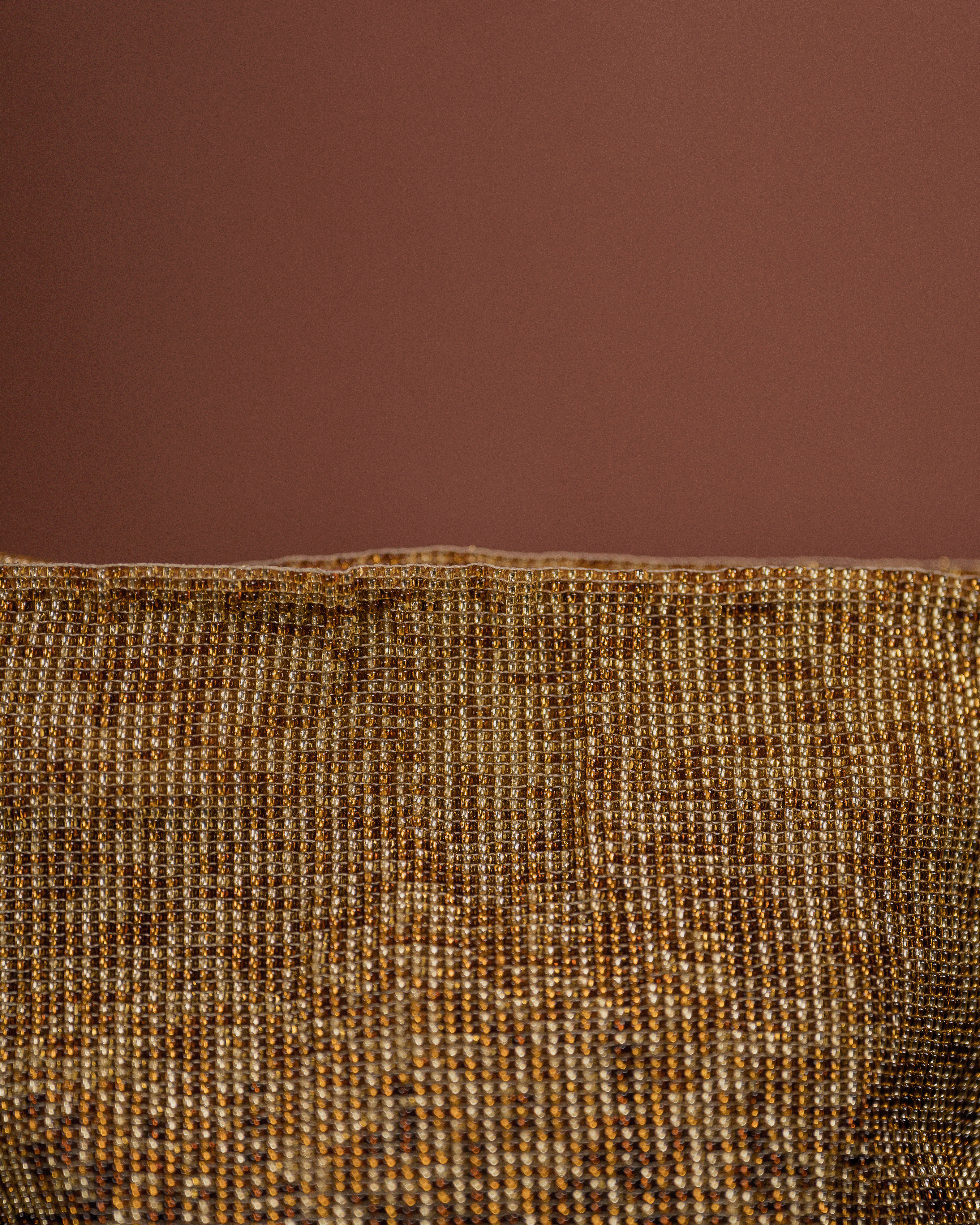 Close-up of a textured brown fabric with a solid brown background
