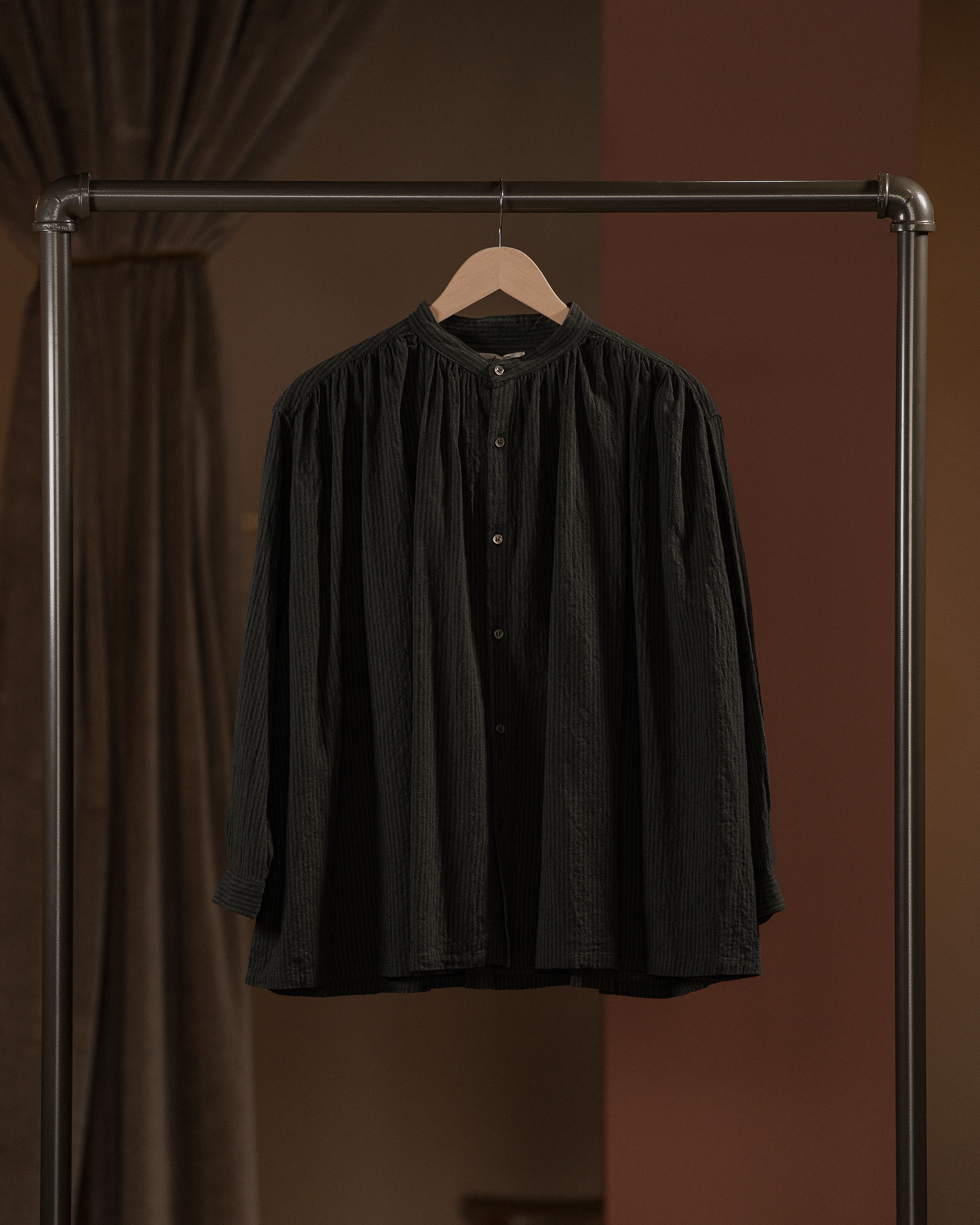 Black shirt on a hanger against a brown background