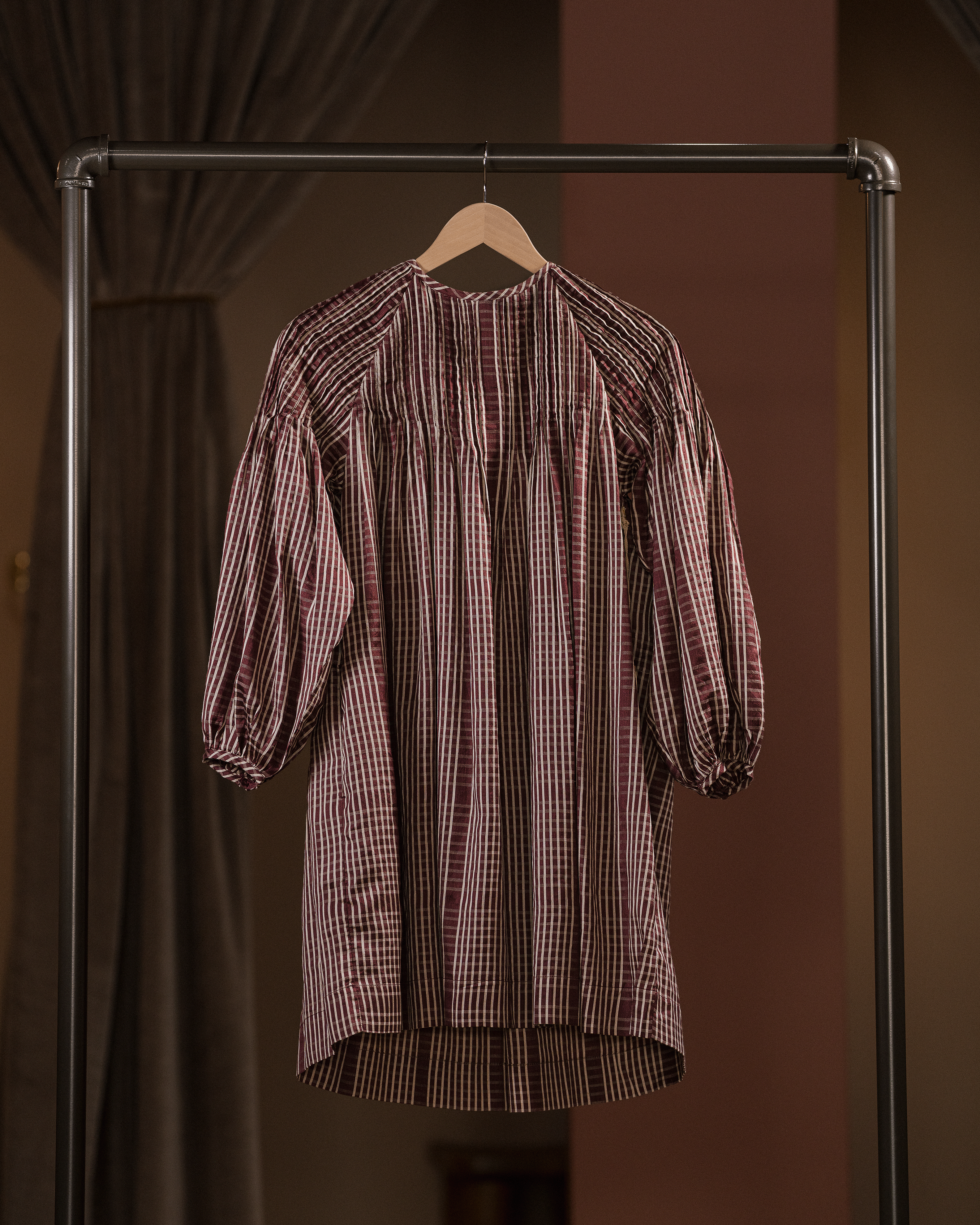 Striped shirt on a hanger against a brown background