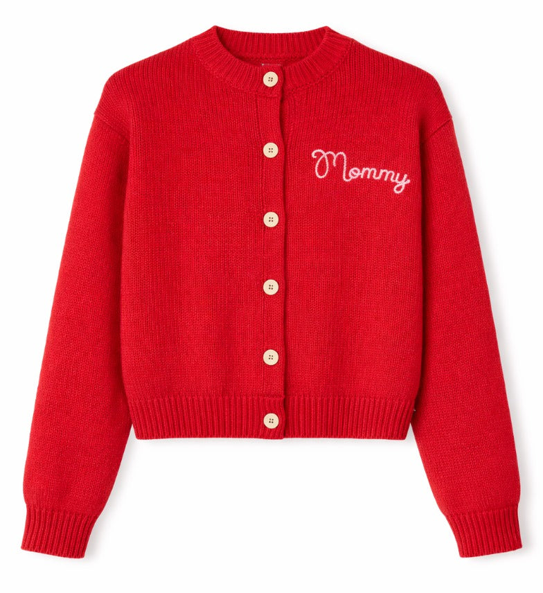 A red ribbed knit cardigan sweater with a crew neck, button closure, and 'Mommy' embroidered in white script on the left chest, shown on a plain white background. Mr. Rogers Mommy Cardigan by Fashion Brand Company.