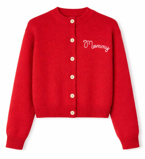 A red ribbed knit cardigan sweater with a crew neck, button closure, and 'Mommy' embroidered in white script on the left chest, shown on a plain white background. Mr. Rogers Mommy Cardigan by Fashion Brand Company.