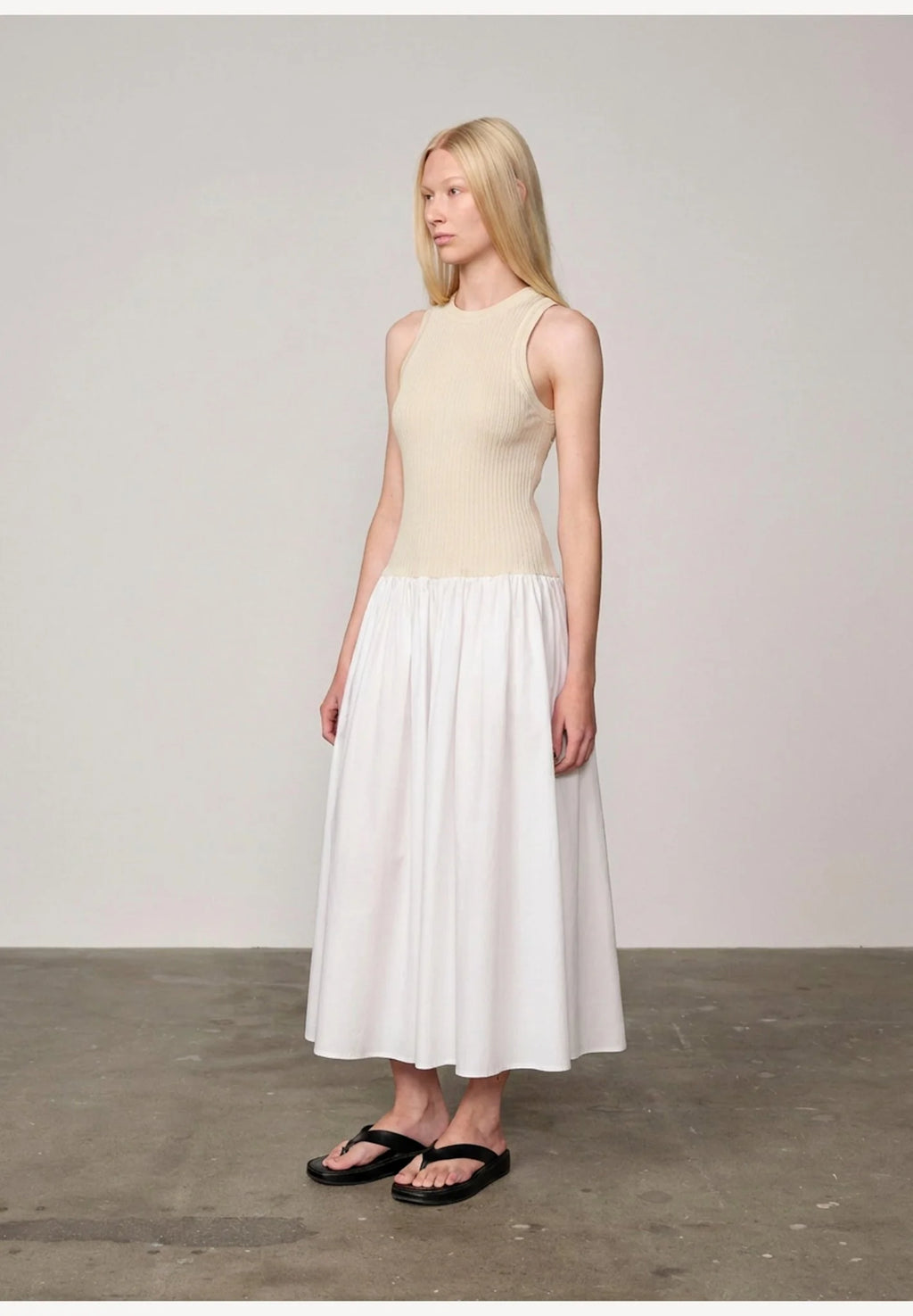 Woman wearing an off white/white watson dress by Herskind against a plain background