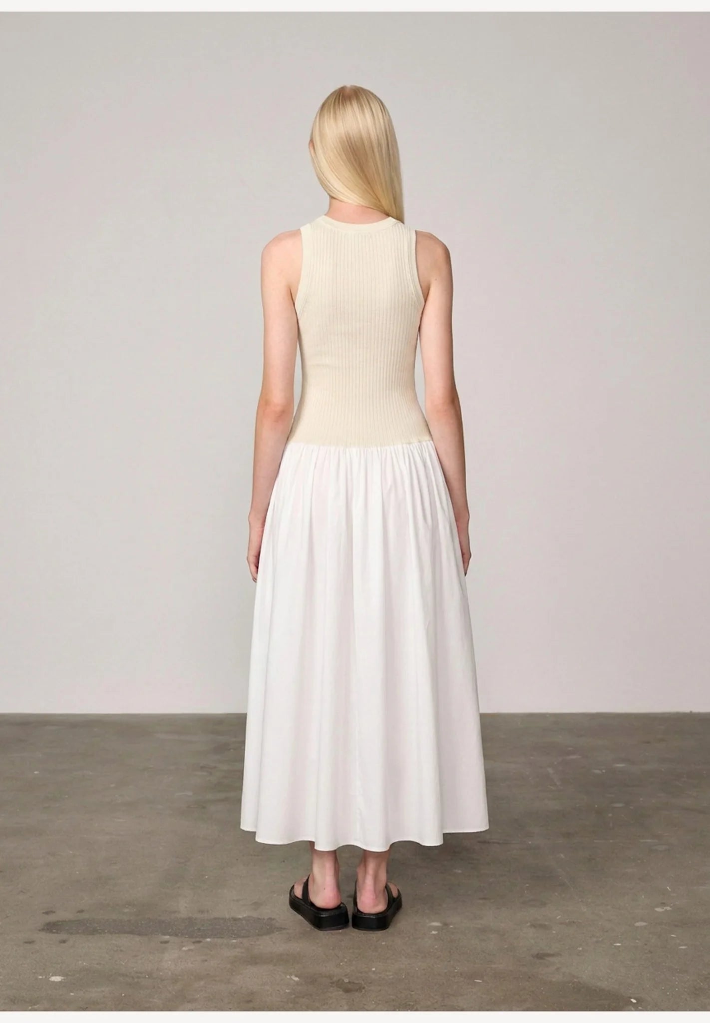 Woman wearing an off white/white watson dress by Herskind against a plain background
