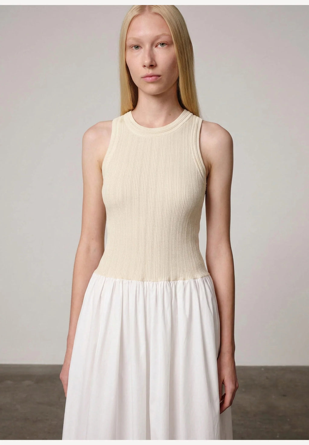 Woman wearing an off white/white watson dress by Herskind against a plain background