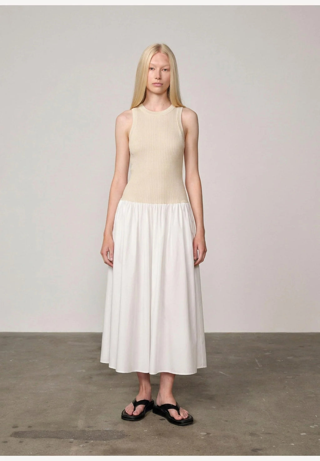 Woman wearing an off white/white watson dress by Herskind against a plain background