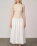Woman wearing an off white/white watson dress by Herskind against a plain background