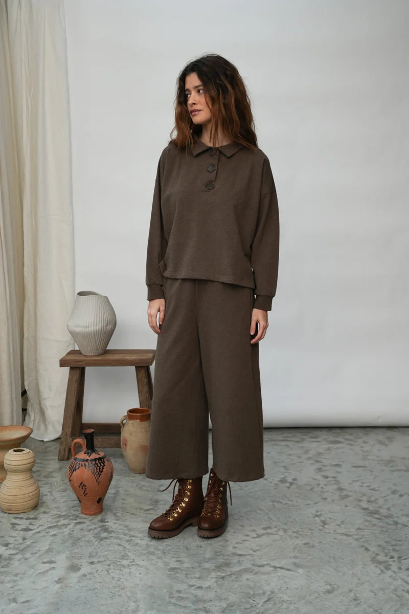 A woman wearing the Holly brown collared Sweatshirt by Beaumont Organic with matching pants.