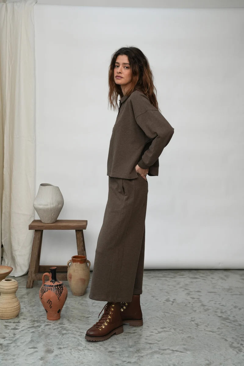 A woman wearing the Holly brown collared Sweatshirt by Beaumont Organic with matching pants.