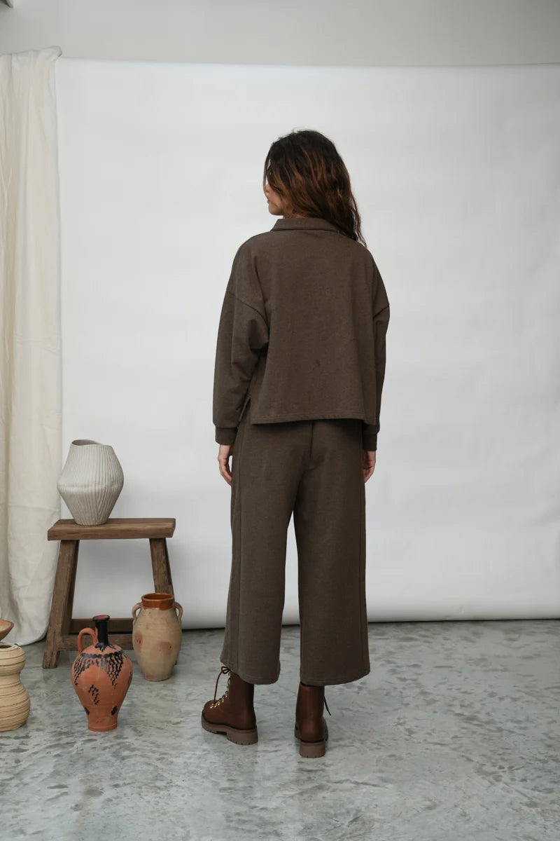 A woman wearing the Holly brown collared Sweatshirt by Beaumont Organic with matching pants.