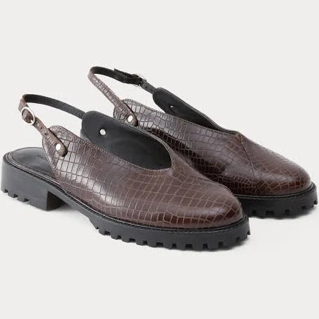 A pair of dark brown clog-style slingback Lenox Lug shoes by Rachel Comey with an embossed crocodile pattern, black platform soles, and adjustable ankle straps, shown against a light gray background.