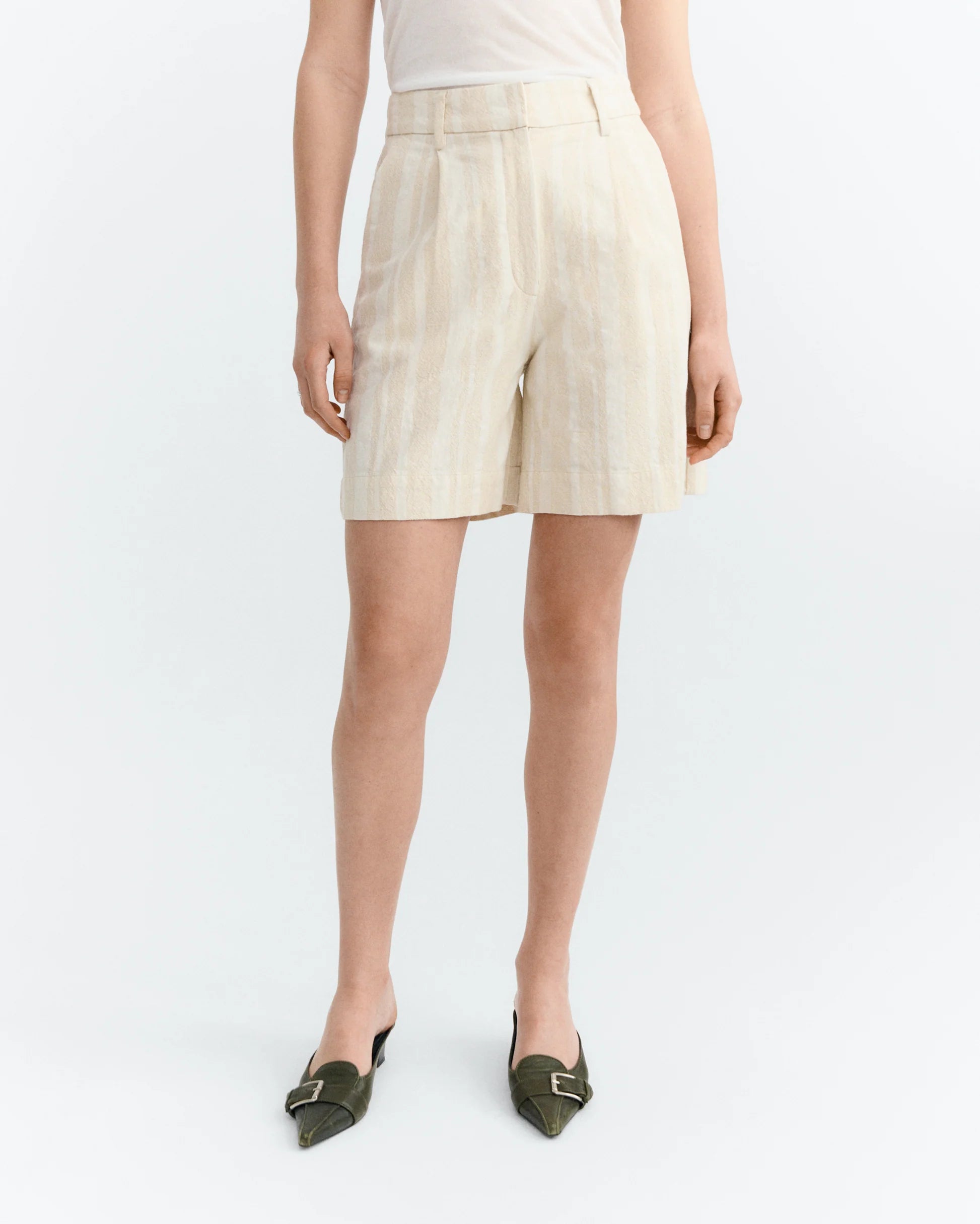 Person wearing raw beige with white stripes shorts on a white background