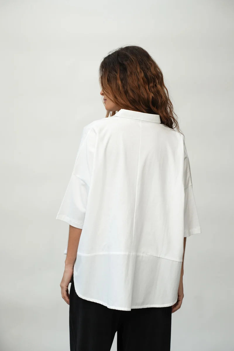 A woman wearing a White Short Sleeve Lissie Blouse by Beaumont Organic