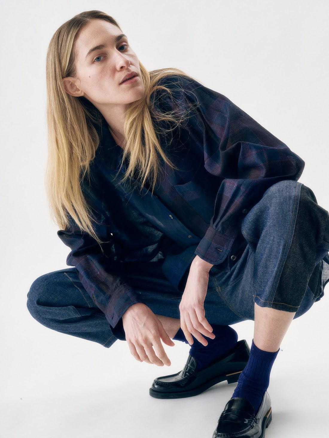 Person wearing a navy outfit with black shoes on a white background