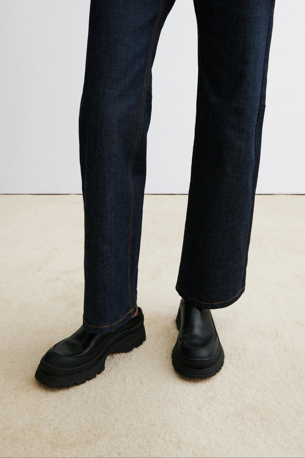 A model with jeans and Black leather Slip in Barla Mule by Rachel Comey.