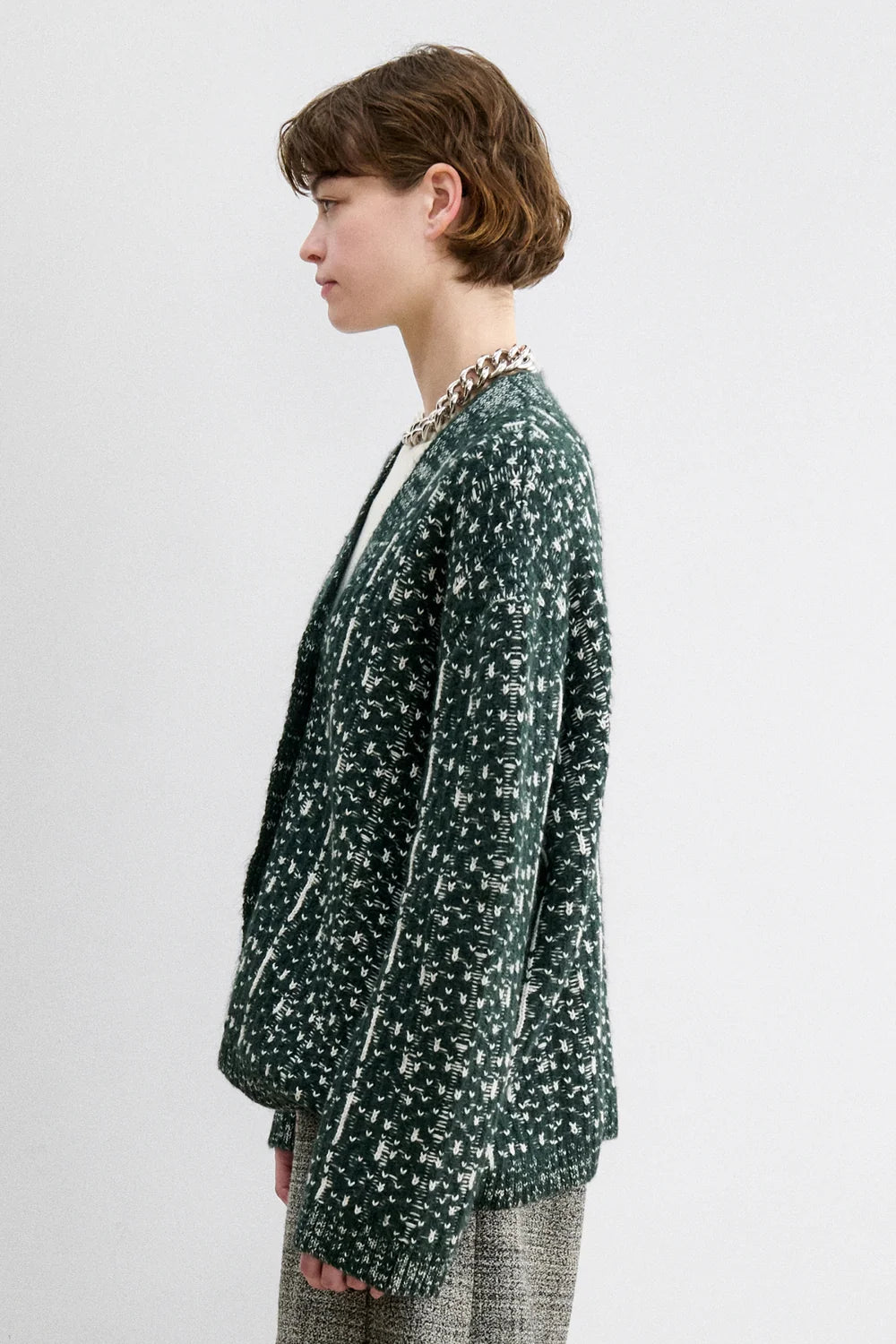 A Model wearing a forest fair isle knit Hedda Cardigan by Rachel Comey with grey shorts.