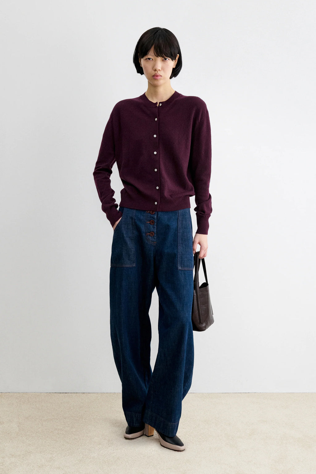 A Model wearing Auburn colored cardigan - Matin Cardigan by Rachel comey and jeans.
