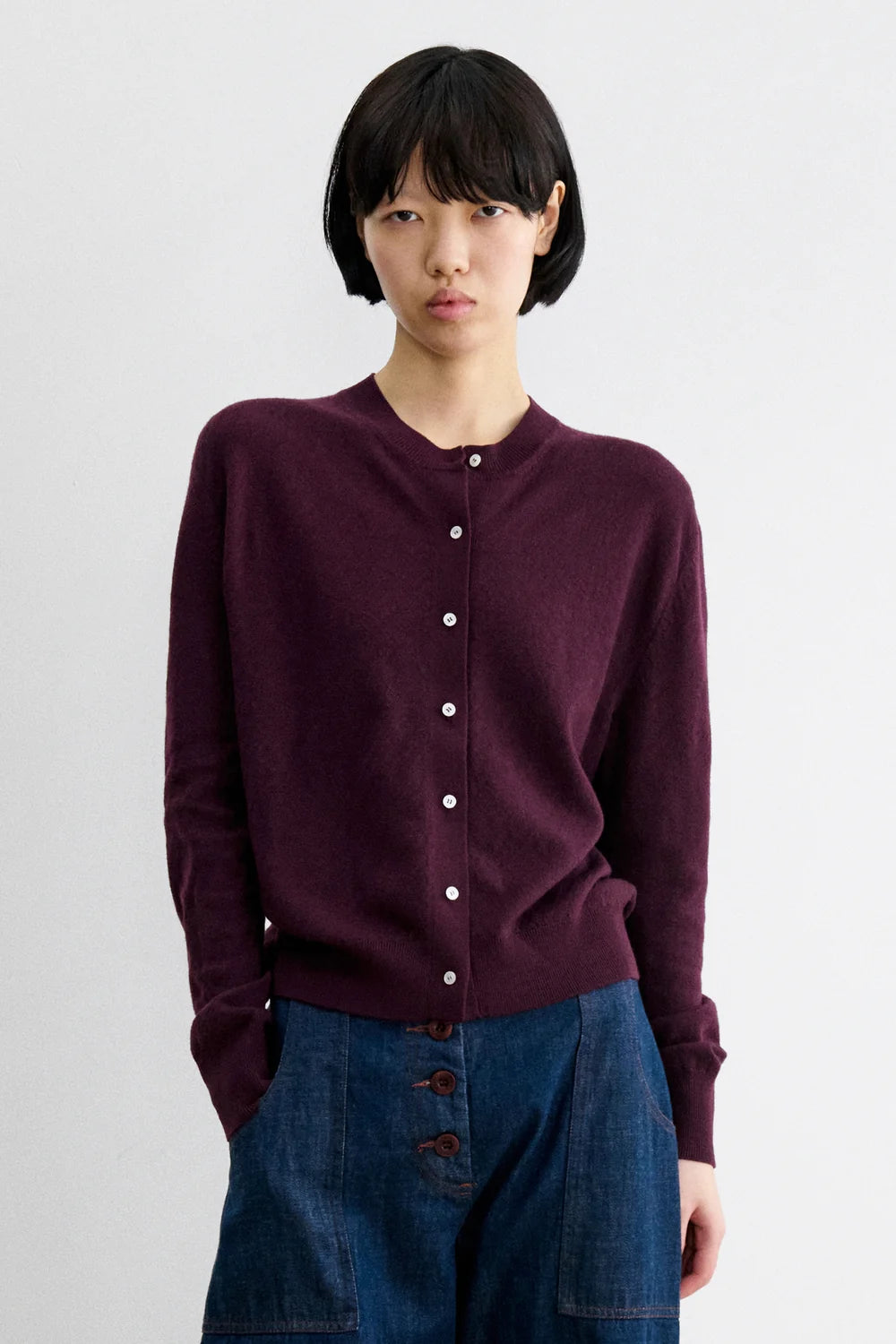 A Model wearing Auburn colored cardigan - Matin Cardigan by Rachel comey and jeans.