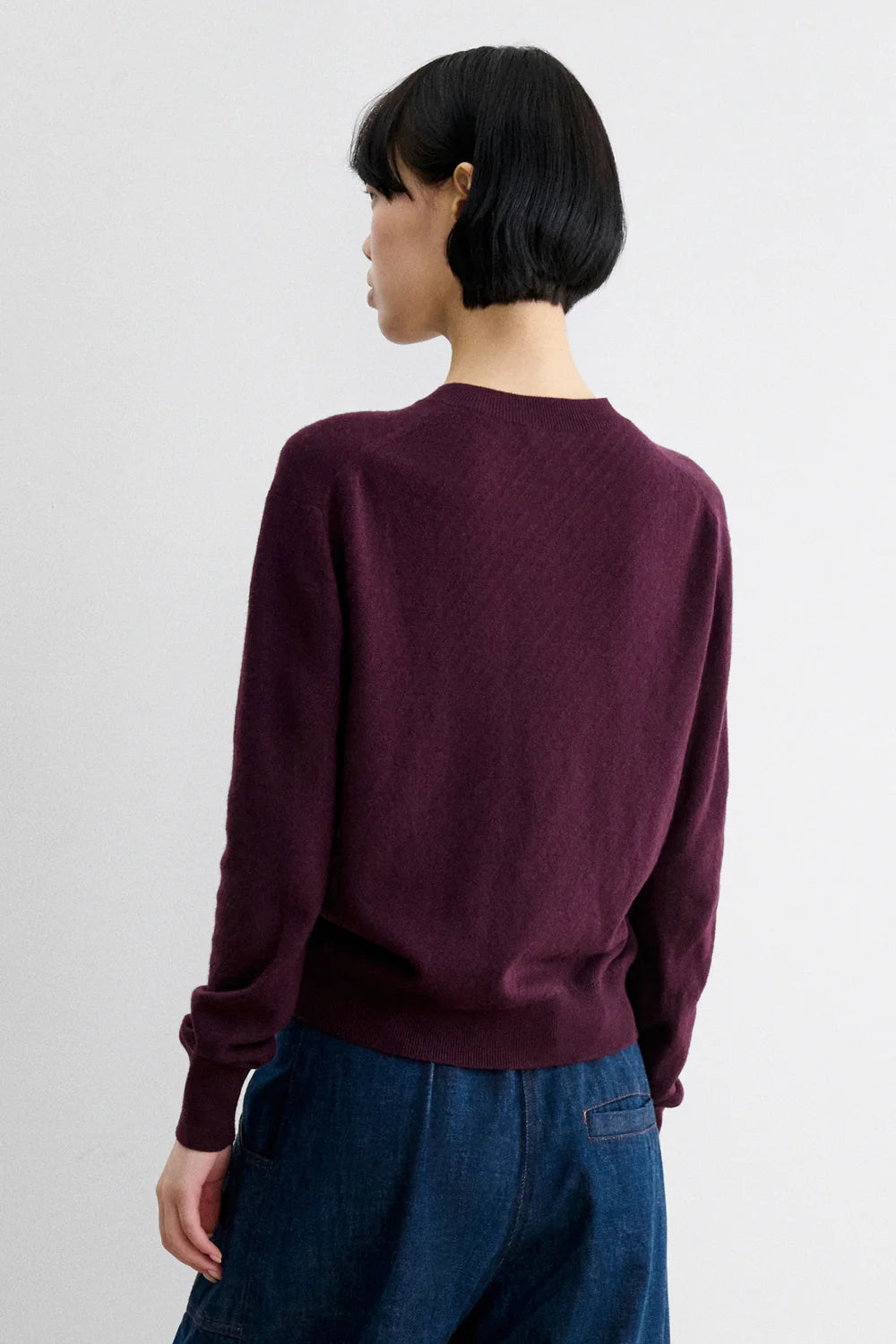 A Model wearing Auburn colored cardigan - Matin Cardigan by Rachel comey and jeans.