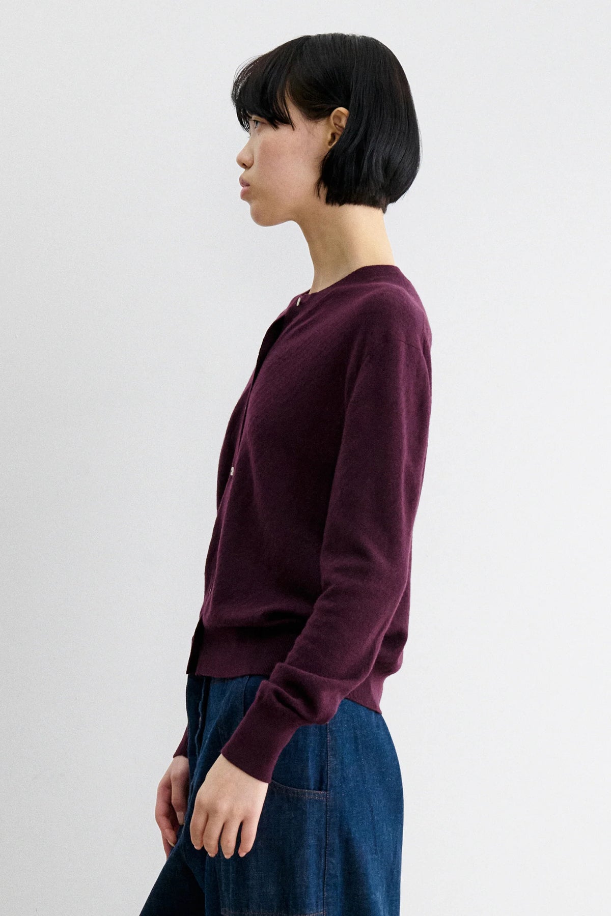 A Model wearing Auburn colored cardigan - Matin Cardigan by Rachel comey and jeans.