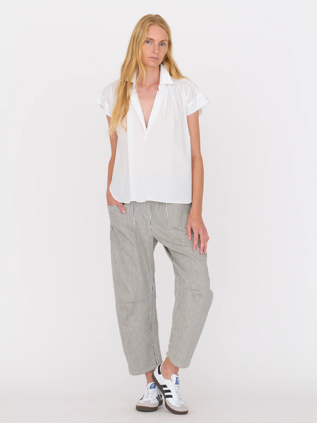 Woman wearing a white blouse and railroad stripe pants by Secular on a white background