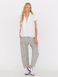 Woman wearing a white blouse and railroad stripe pants by Secular on a white background