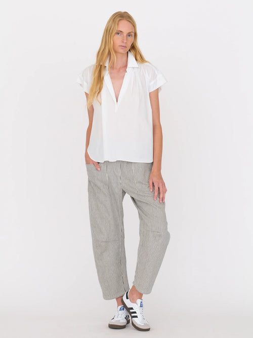 Woman wearing a white blouse and railroad stripe pants by Secular on a white background
