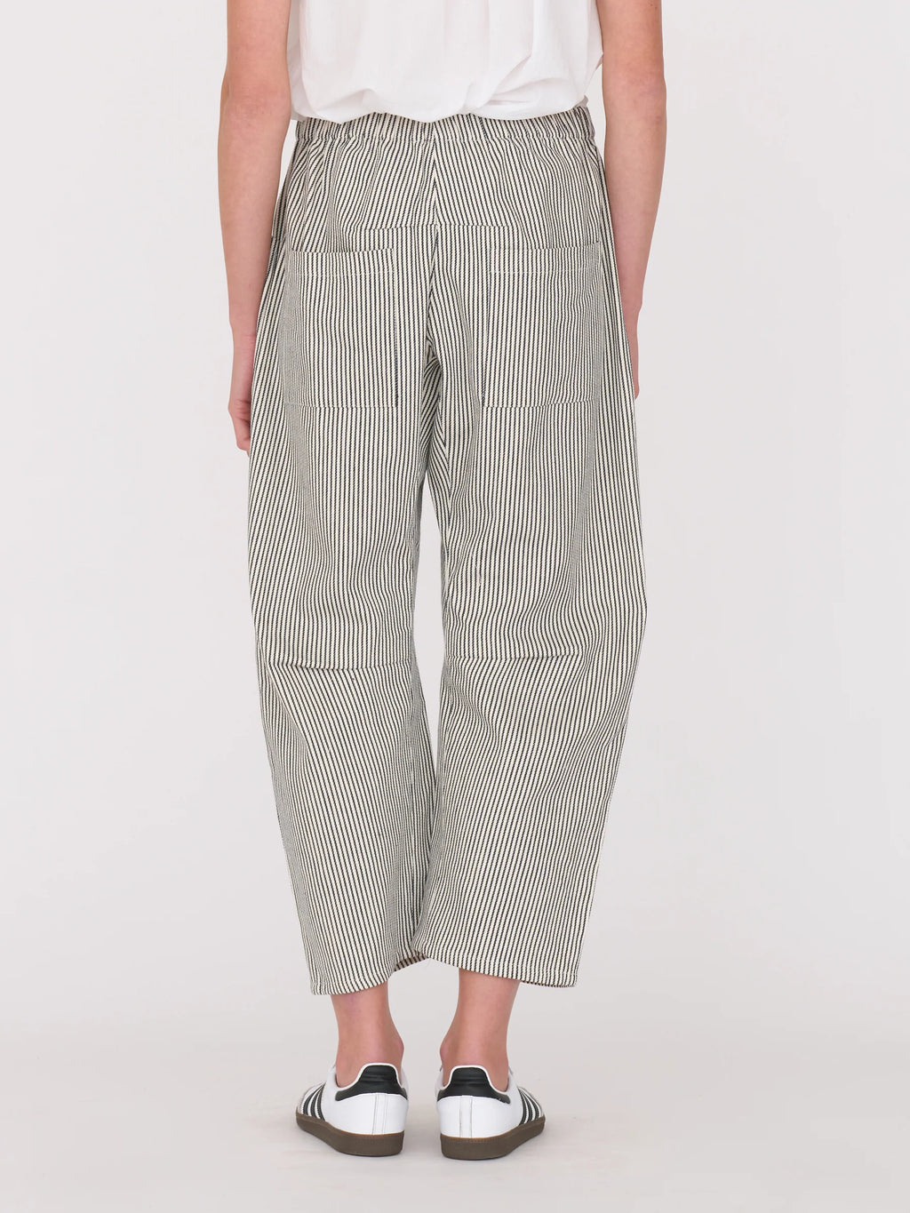 Woman wearing a white blouse and railroad stripe pants by Secular on a white background