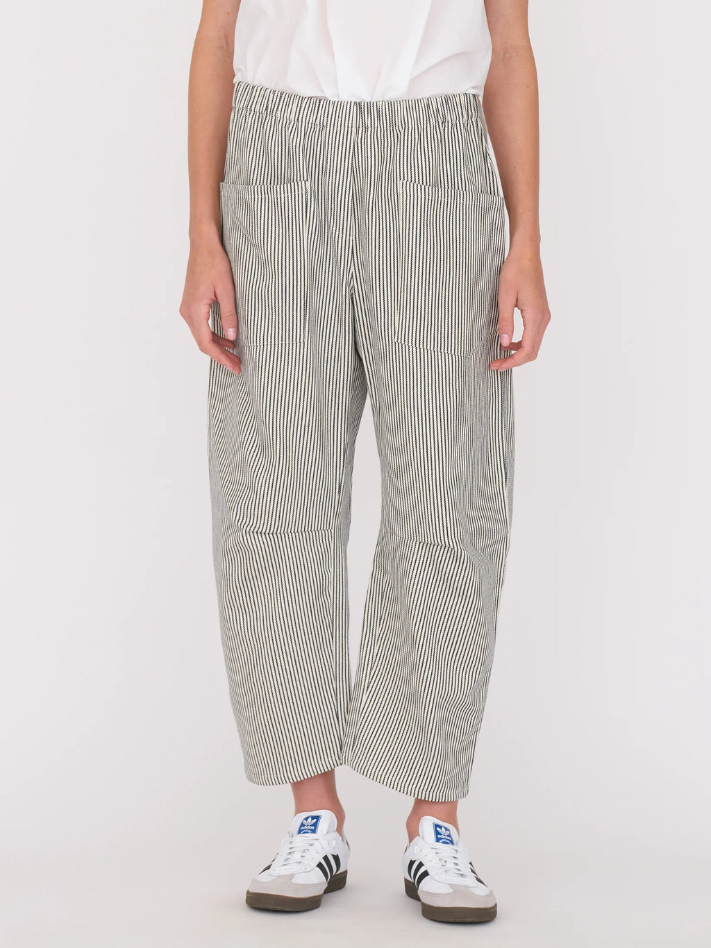 Woman wearing a white blouse and railroad stripe pants by Secular on a white background