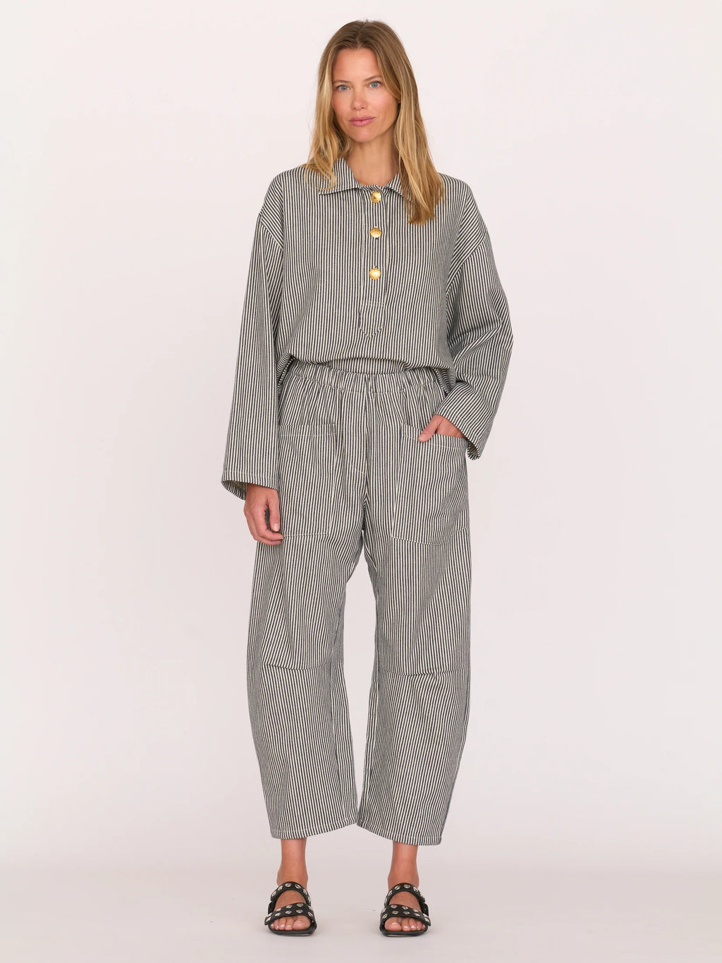 Woman wearing a gray railroad striped walker top by Secular on a white background