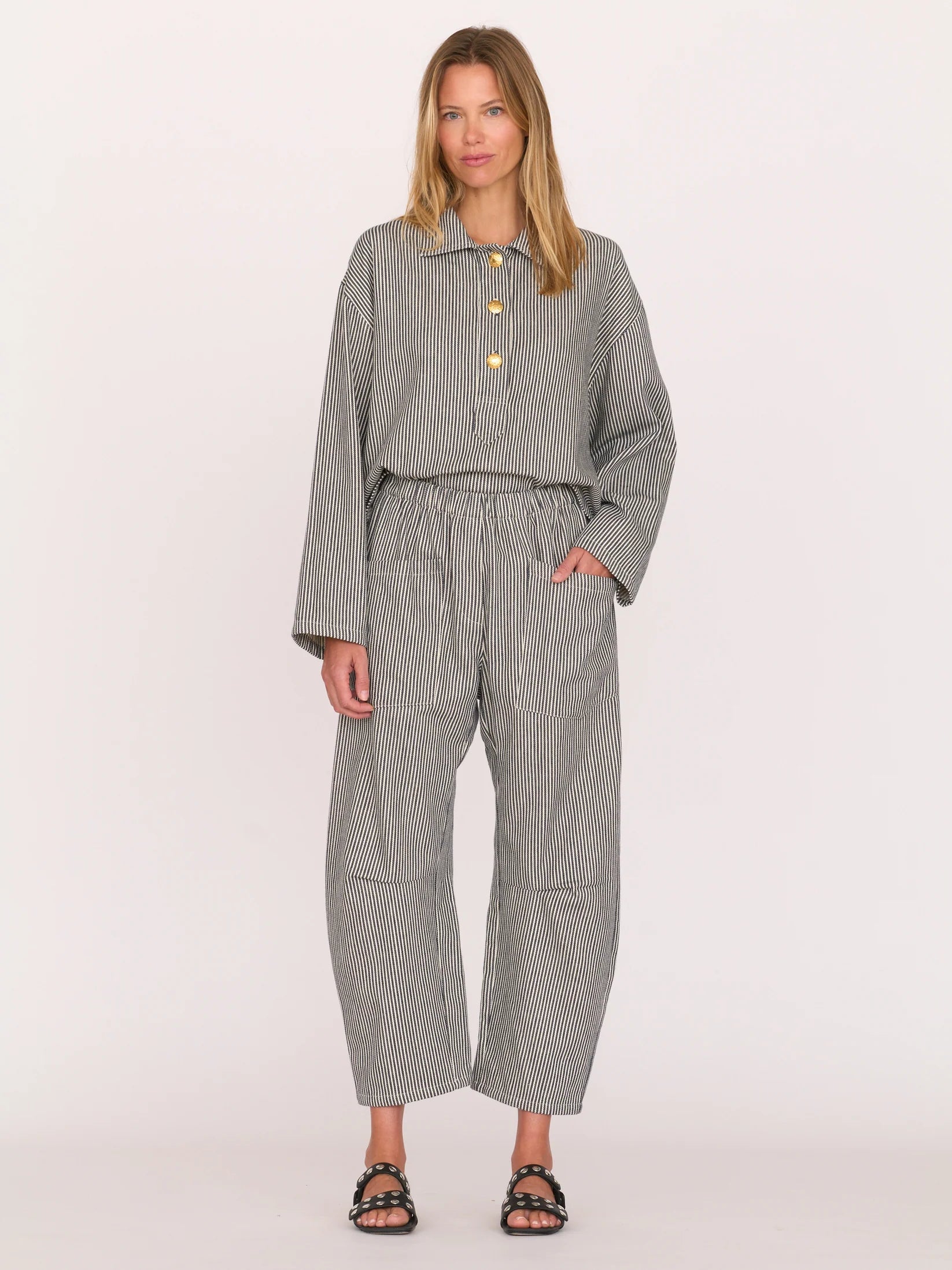 Woman wearing a gray railroad striped walker top by Secular on a white background
