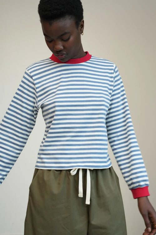 A Model wearing a striped Sierra Sue Long Sleeve T-shirt in Pewter Blue/off white and contrast red collar/ cuffs by Beaumont Organic.