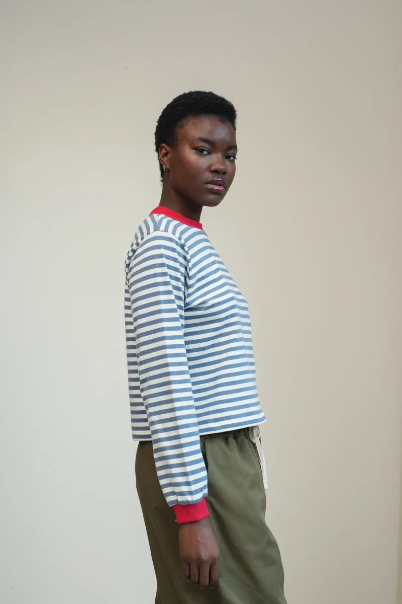 A Model wearing a striped Sierra Sue Long Sleeve T-shirt in Pewter Blue/off white and contrast red collar/ cuffs by Beaumont Organic.