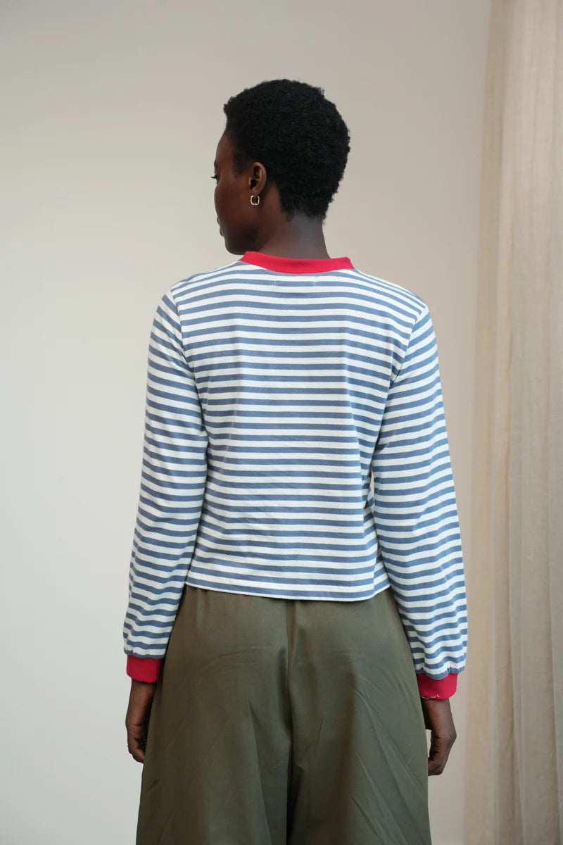 A Model wearing a striped Sierra Sue Long Sleeve T-shirt in Pewter Blue/off white and contrast red collar/ cuffs by Beaumont Organic.