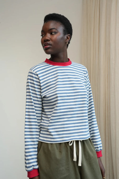 A Model wearing a striped Sierra Sue Long Sleeve T-shirt in Pewter Blue/off white and contrast red collar/ cuffs by Beaumont Organic.