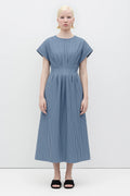 Woman wearing a Sybille Dress with blue stripes by Rita Row against a white background