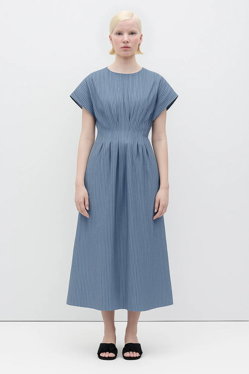 Woman wearing a Sybille Dress with blue stripes by Rita Row against a white background