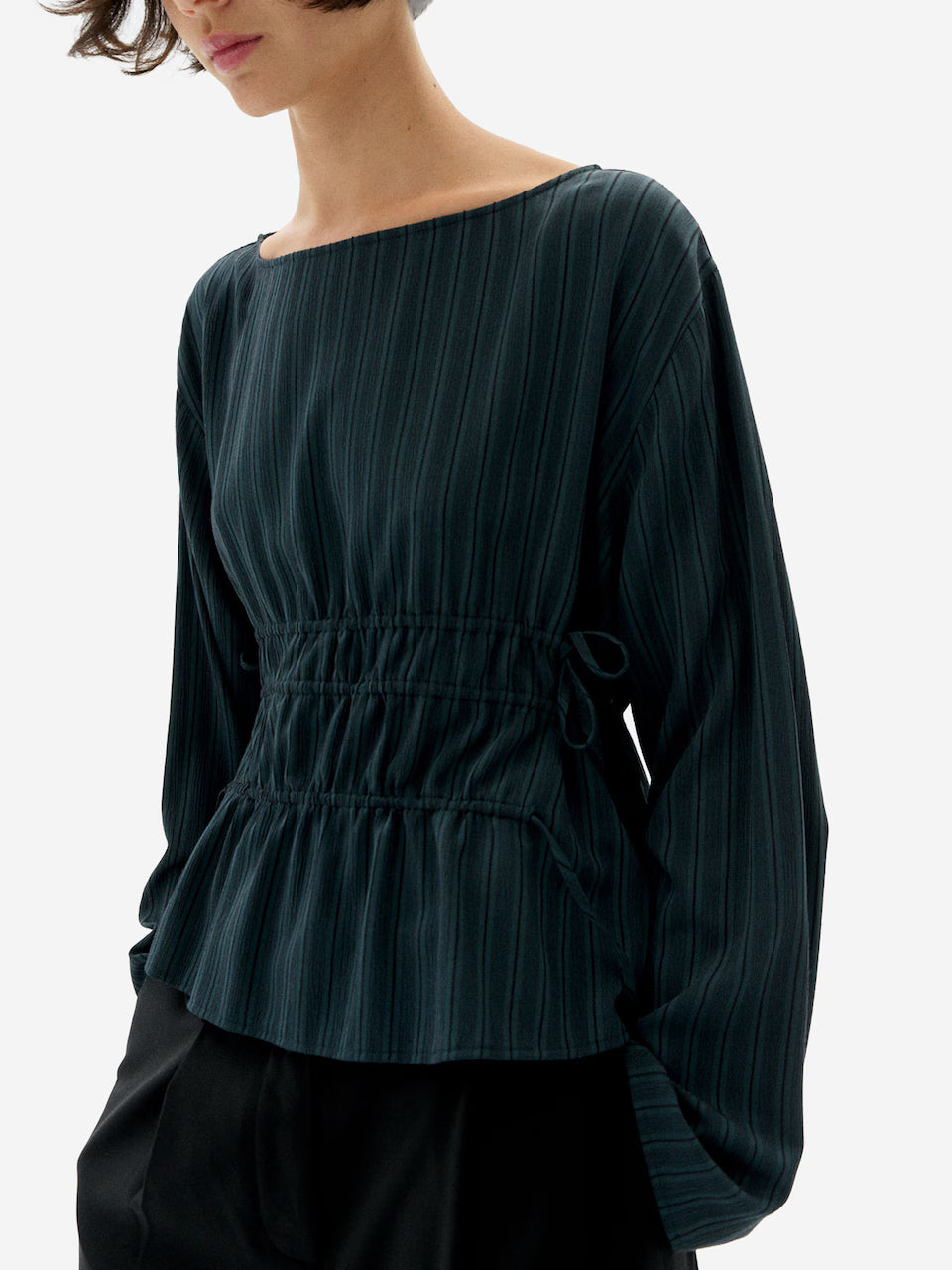 Woman waring Faded Dark Green striped Devin Blouse by Thinking Mu on a white background.